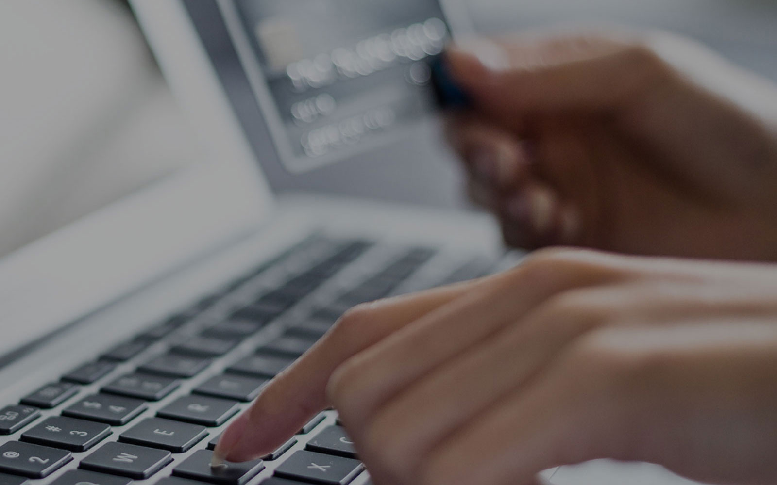 hands on keyboard and holding credit card