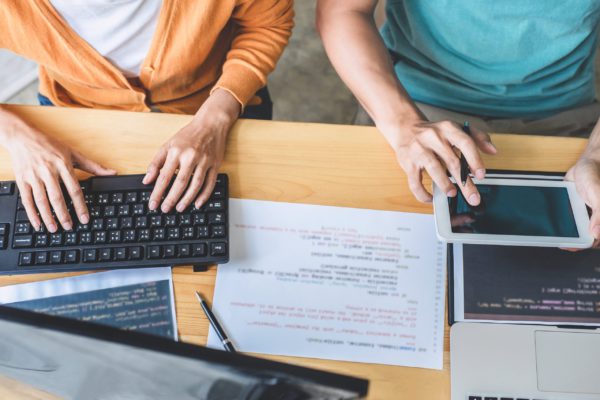 Two professional programmer cooperating and working on web site Two professional programmer cooperating and working on web site