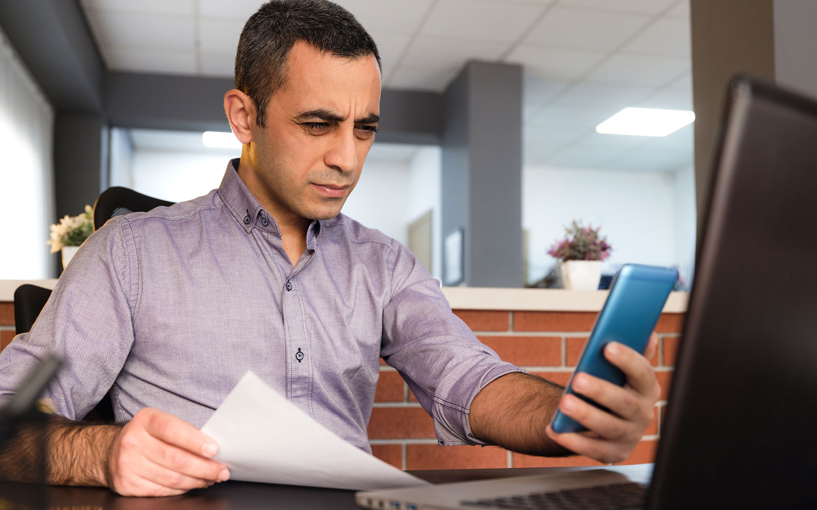 Man squinting to read phone