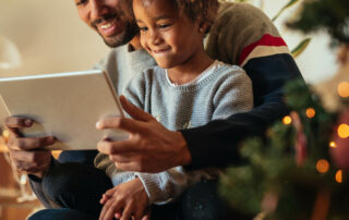 Father reading to his daughter from a tablet