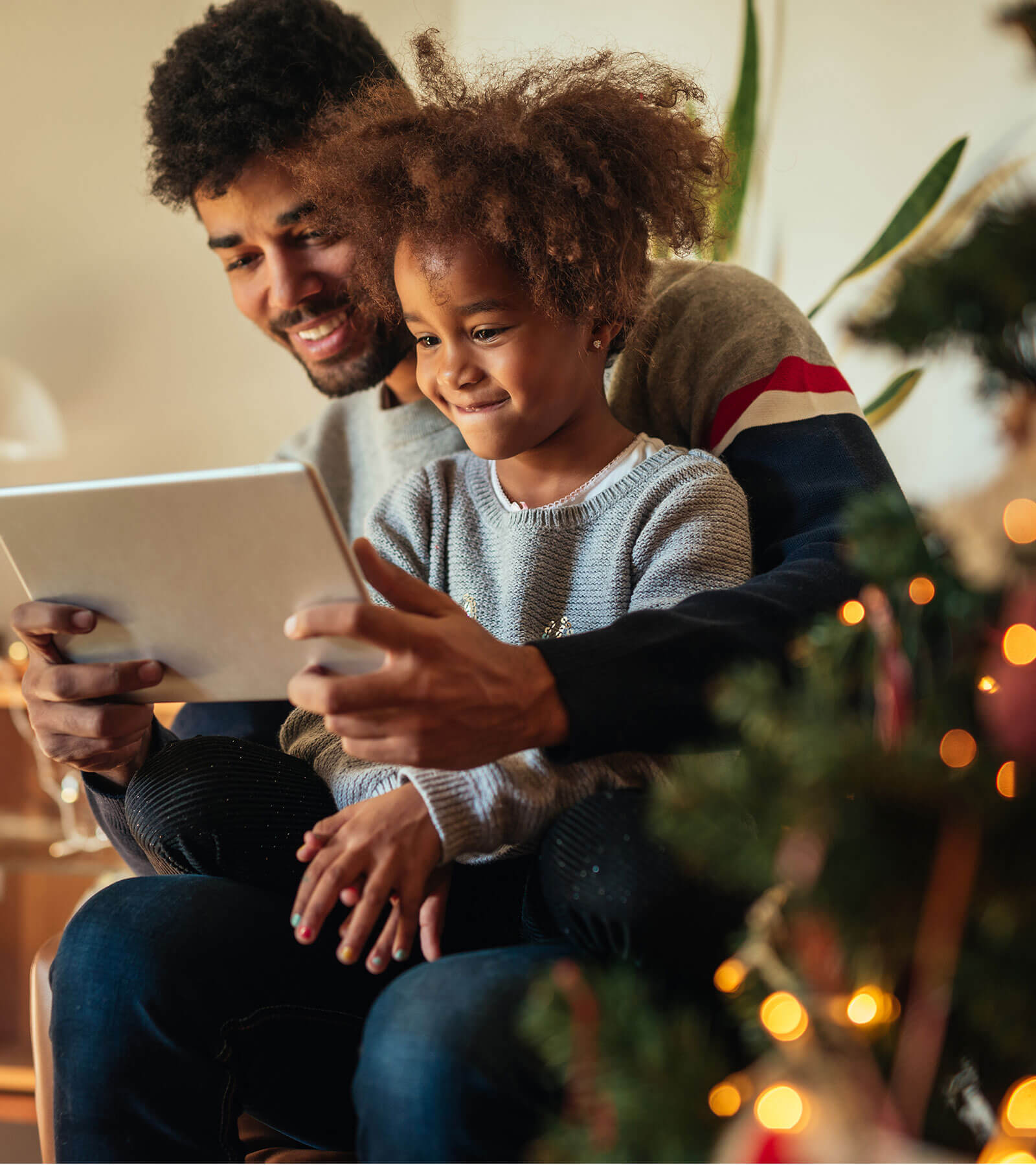 Father reading to his daughter from a tablet