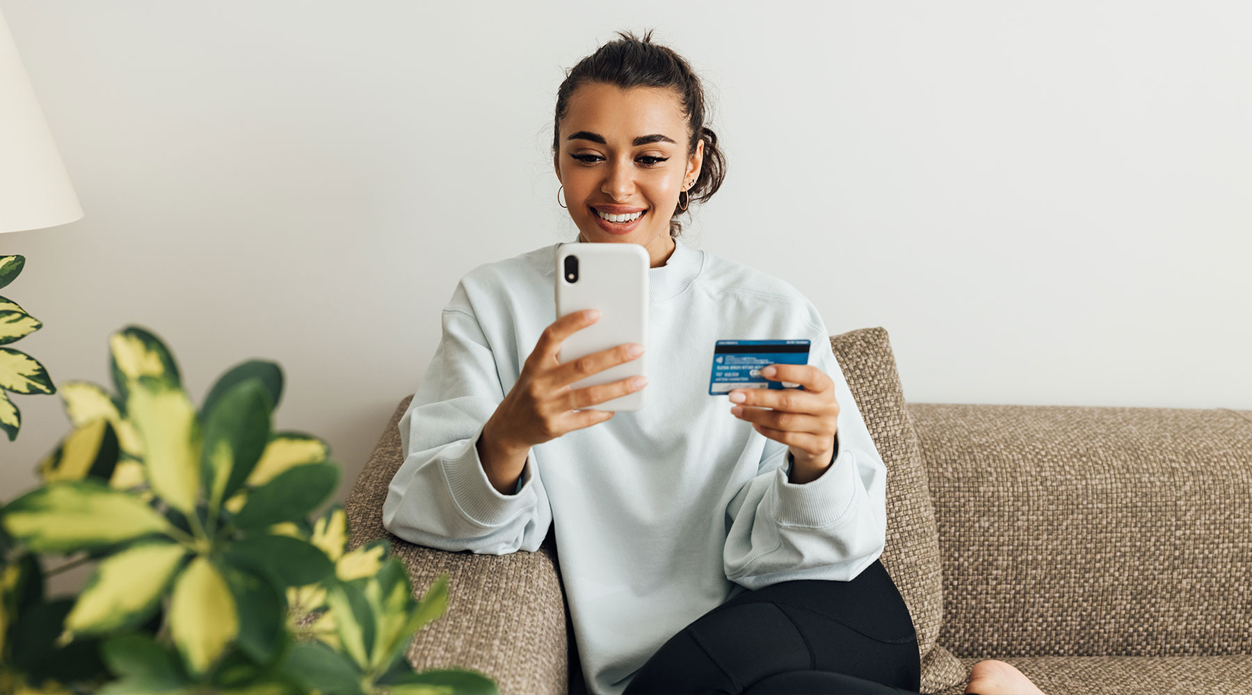 Woman holding phone and credit card