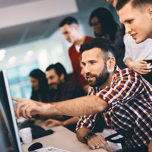 Man pointing at screen for colleague to read