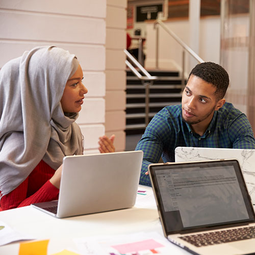 Woman in hijab in discussion with male co-worker