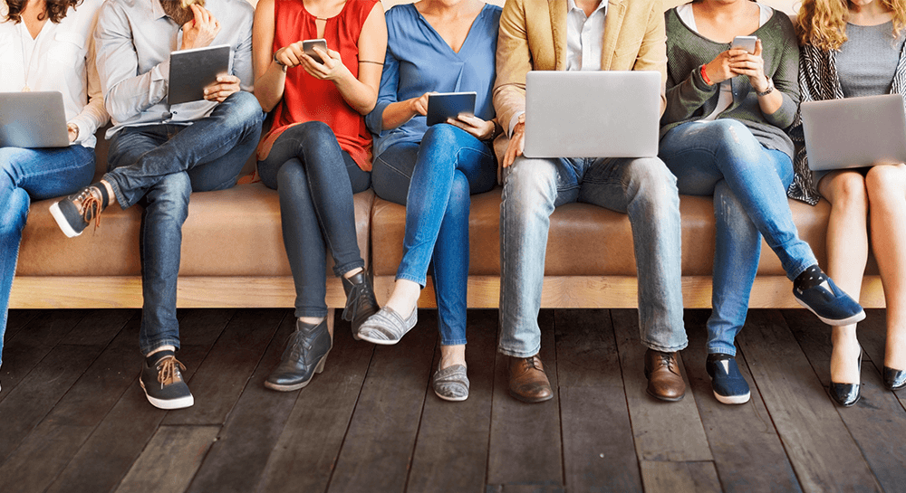 Group on sofa, using difference devices