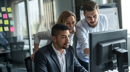 A team gathered around a computer screen