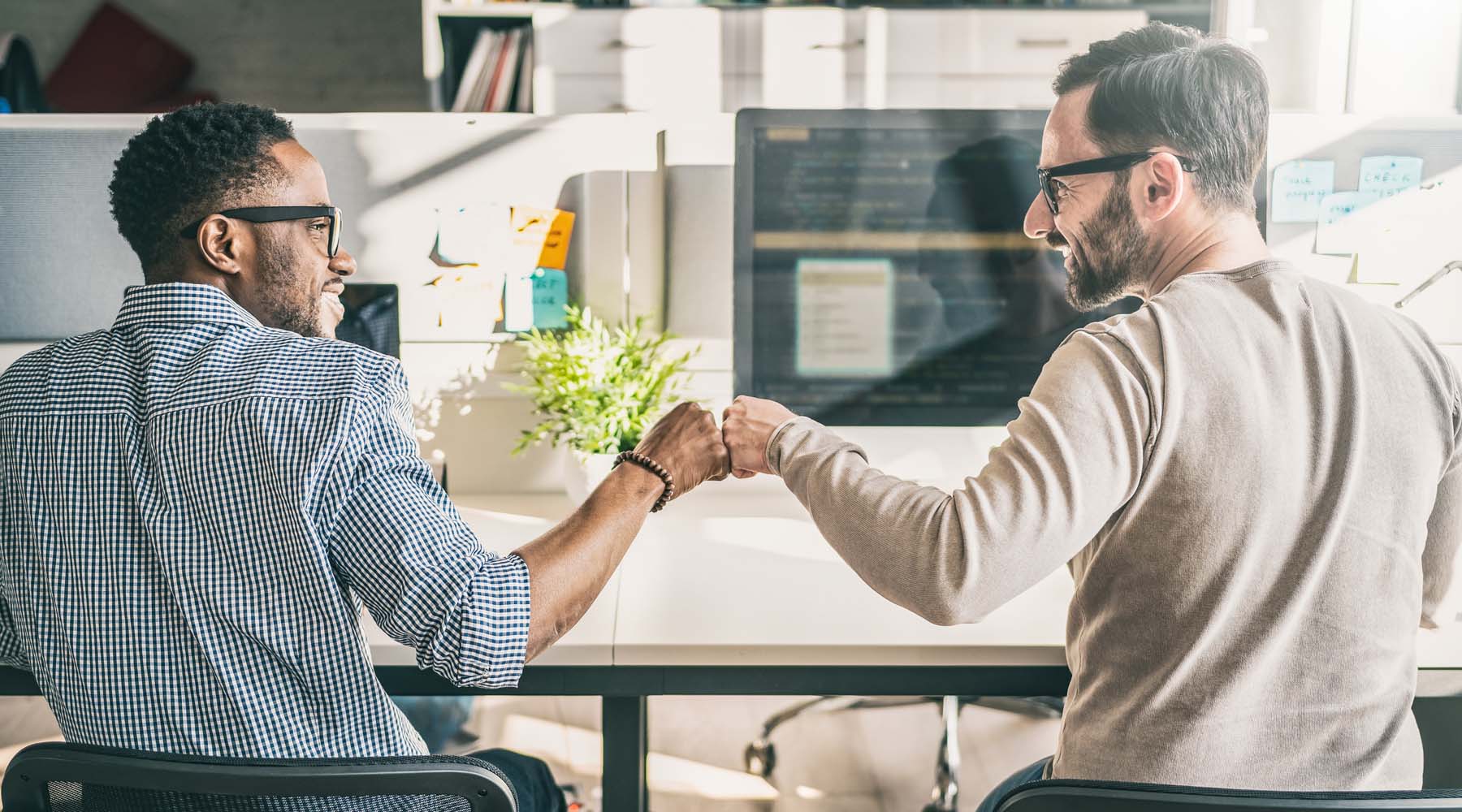 a developer and a tester fist pump to celebrate a successful release